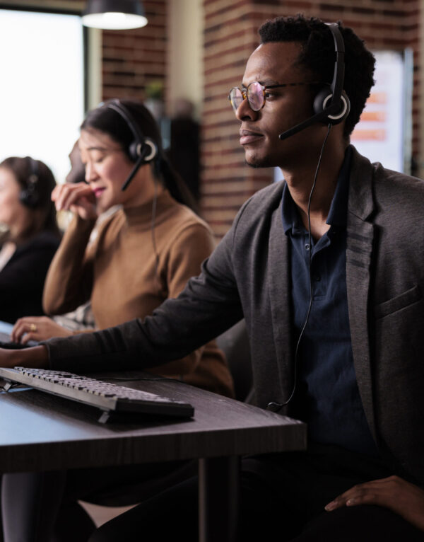Operator answering client phone call at customer care service Operator answering client phone call at customer care service, helping people at call center support. Male receptionist giving telemarketing assistance on phone helpline in office.